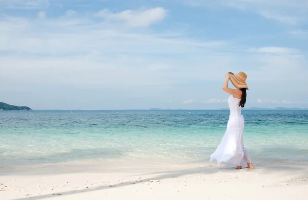 Kobieta w kapeluszu na linii brzegowej na tropikalnej plaży — Zdjęcie stockowe