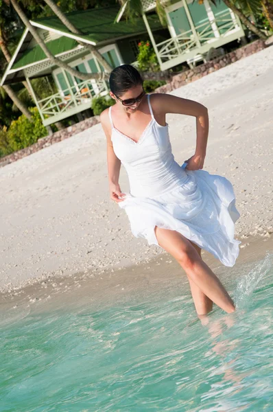 Beautiful woman walking along seaside on tropical beach — Stock Photo, Image