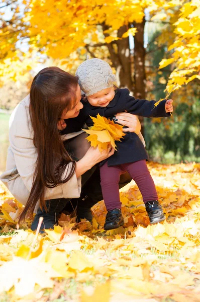 年轻快乐的母亲带着女儿在片秋色的公园 — 图库照片