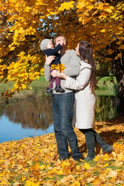 Ung familj koppla av utomhus i höst park — Stockfoto