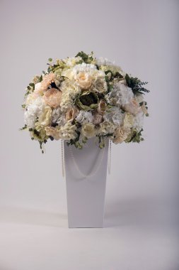 Yapay çiçek buketi beyaz izole vazoda