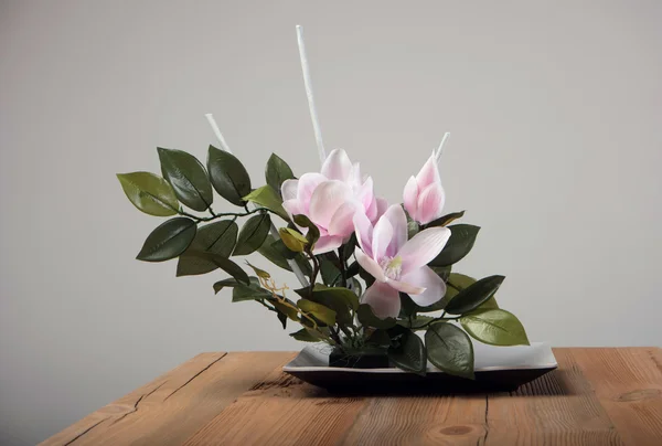 Ramo de flores artificiales en jarrón sobre la mesa —  Fotos de Stock