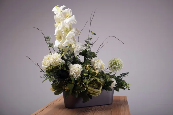 Ramo de flores artificiales en jarrón sobre la mesa —  Fotos de Stock