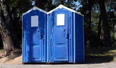 Two portable toilet cabins in park at dry sunny summer da