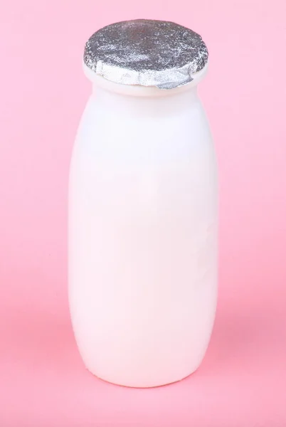 Белая бутылка на розовом фоне — стоковое фото