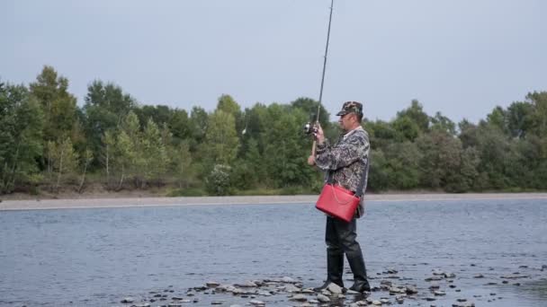 Pescador captura un pez en un spinning — Vídeo de stock