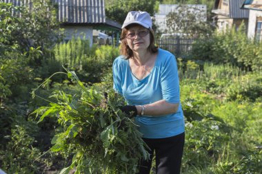 Onun bahçede otlar ayıklayacaktır kadın bahçıvan