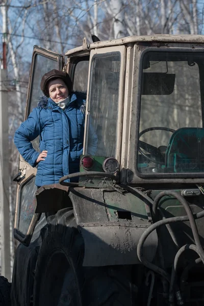 Mulher agricultor com um trator velho — Fotografia de Stock