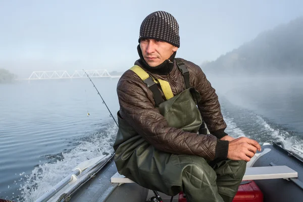 man steers the boat with outboard motor