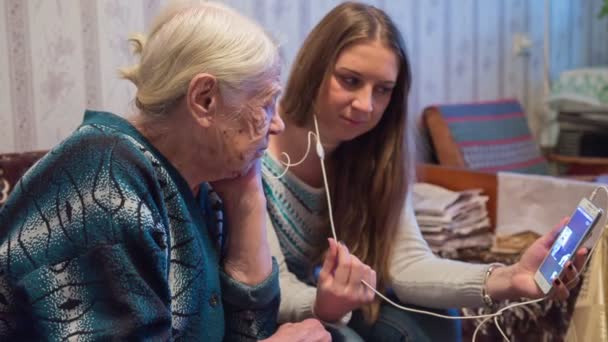 Бабушка и внучка разговаривают по видеоконференции с родственниками — стоковое видео