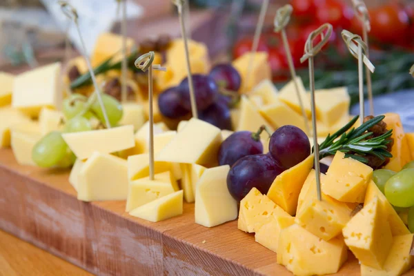 Käse und Trauben auf dem Holzbrett Stockfoto