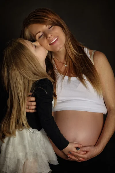 Córka całuje matkę w ciąży — Zdjęcie stockowe