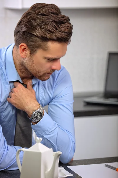 Nadenkend jonge zakenman koffie drinken in de keuken — Stockfoto