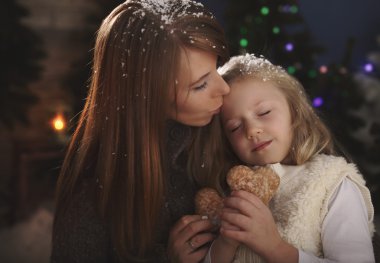 Anne ve kızı kış akşamları kucaklamak