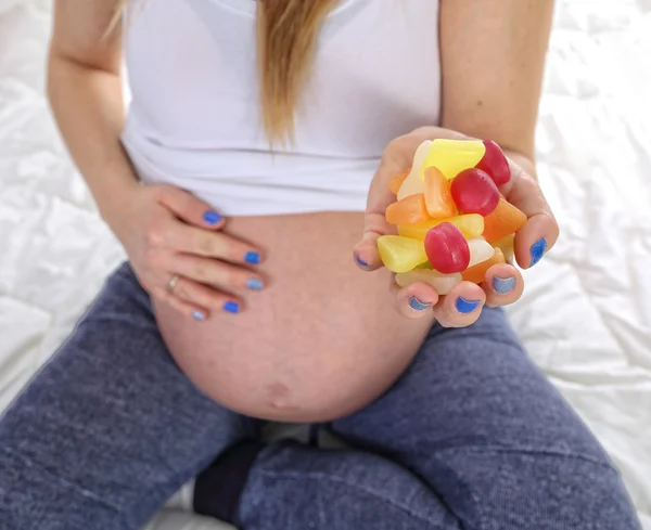 Hamile kadın sağlıksız şeker yiyor — Stok fotoğraf