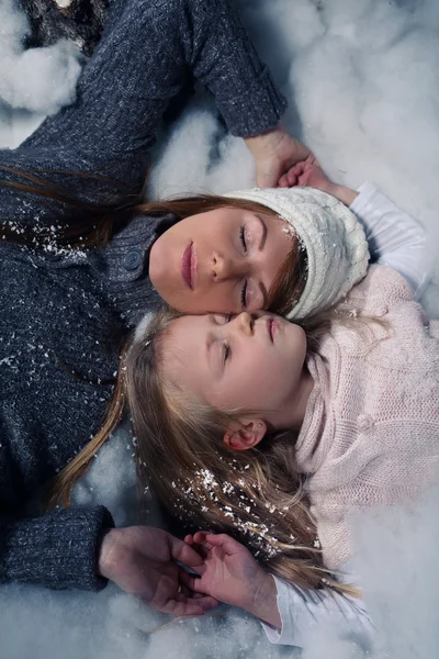 Figlia e madre sdraiati sulla neve — Foto Stock