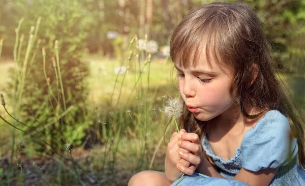 Młoda dziewczyna z mniszka lekarskiego na łące — Zdjęcie stockowe