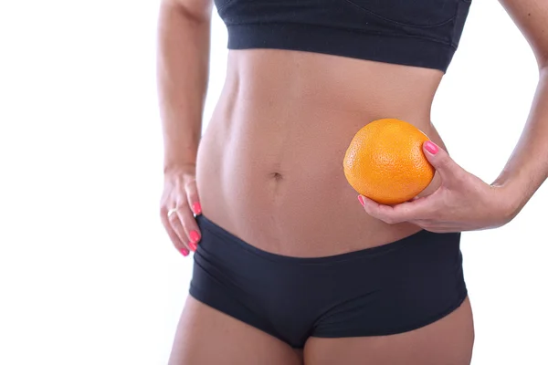 Mädchen mit flachem Bauch, der orange hält — Stockfoto