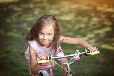 Bir bisiklet üzerinde genç sevimli kız