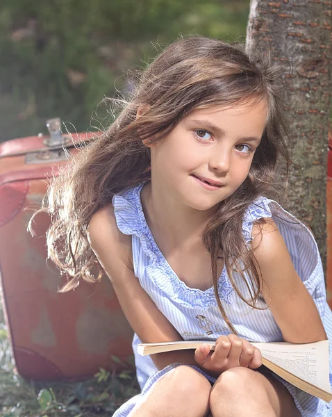 Smiling and happy young girl reading a book — Stock Photo, Image