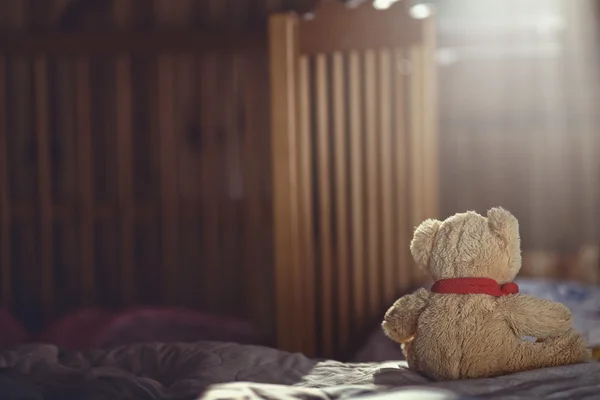 Teddy bear in an empty child's room — Stock Photo, Image