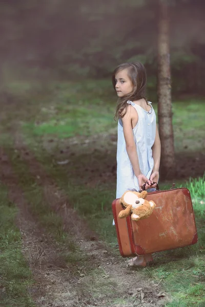 Young girl barefoot in the woods with a suitcase — Stock Photo, Image