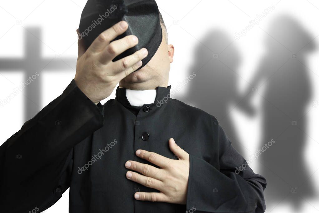 priest covering his face on a children shadow background