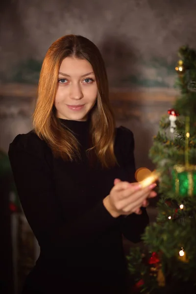 若い女の子がクリスマスツリーを飾る — ストック写真