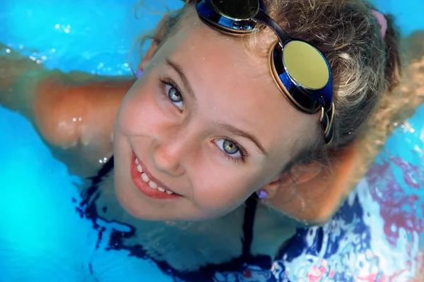 Das kleine Mädchen schwimmt an einem heißen Tag am Pool — Stockfoto