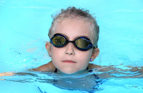 Das kleine Mädchen schwimmt an einem heißen Tag am Pool — Stockfoto