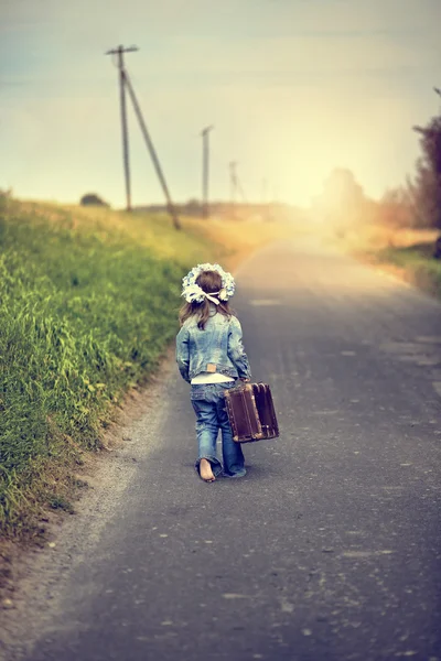 Flicka med en resväska går på ett äventyr — Stockfoto
