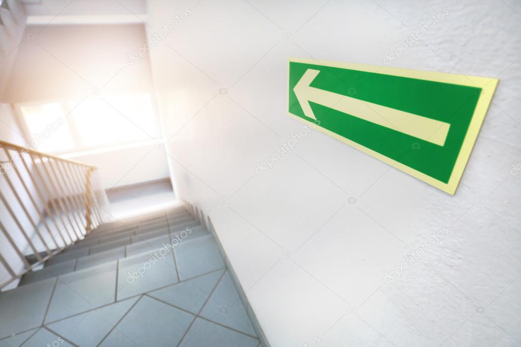 Emergency exit with green arrow sign