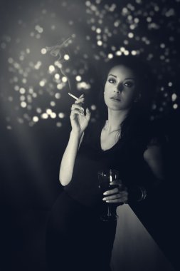 Sigarada gece elbisesi bardaki ile ayakta hauntingly güzel kadın
