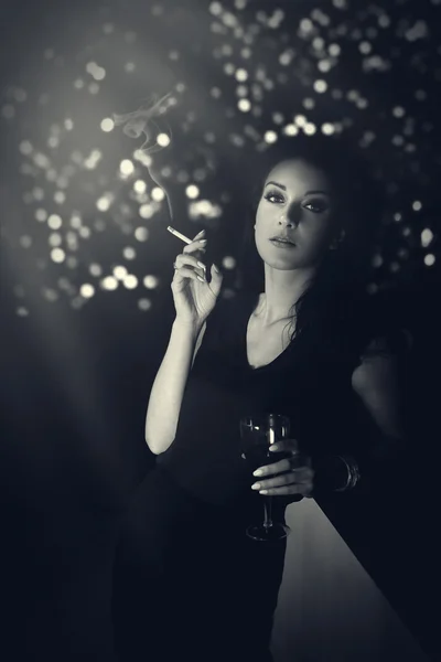 Hauntingly beautiful woman standing with a cigarette in evening gown at the bar — Stock Photo, Image