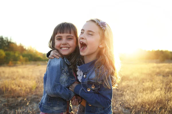 Two cheerful friends snuggling outdoors in the park — Stock Photo, Image