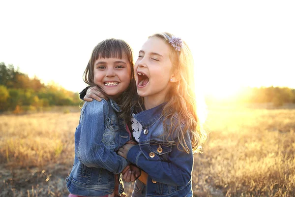 Two cheerful friends snuggling outdoors in the park — Stock Photo, Image