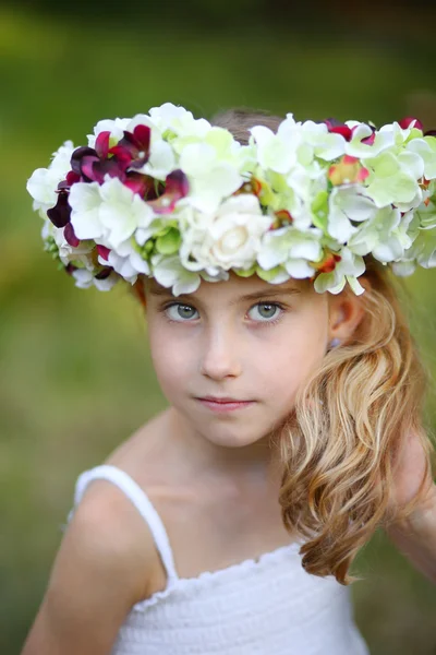 Niña feliz en una corona floral —  Fotos de Stock