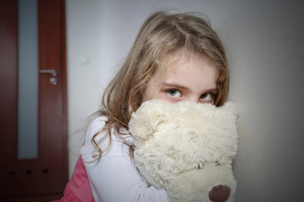 Young sad girl hugging a teddy bear — Stock Photo, Image