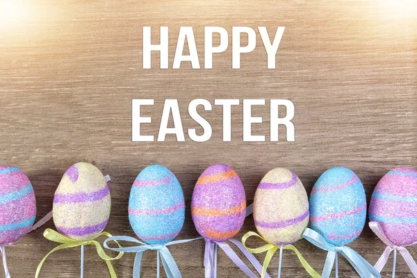 Satır ahşap arka plan üzerinde renkli Paskalya yortusu yumurta — Stok fotoğraf