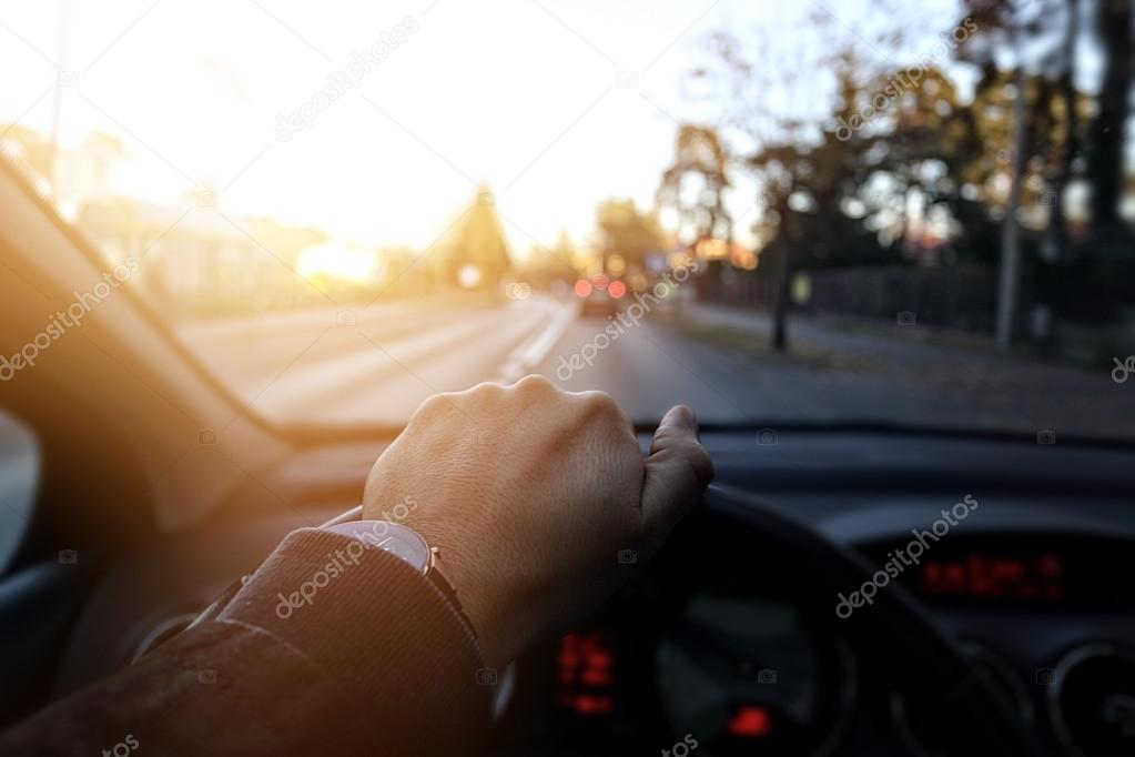 The driver goes down the street in sunny day