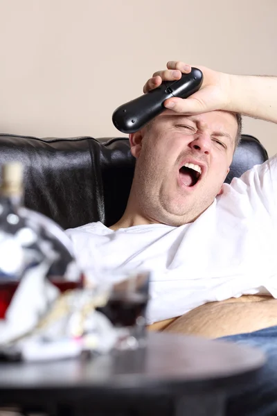 Yawning manusia di sofa menonton TV — Stok Foto