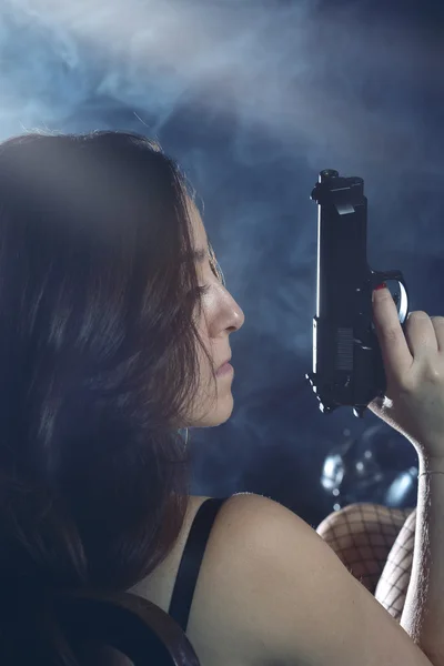 Enigmatic and mysterious woman with gun — Stock Photo, Image