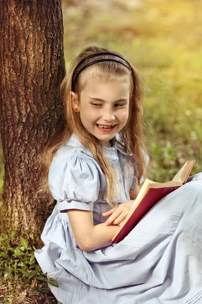 Delighted young girl reading a book — Stock Photo, Image