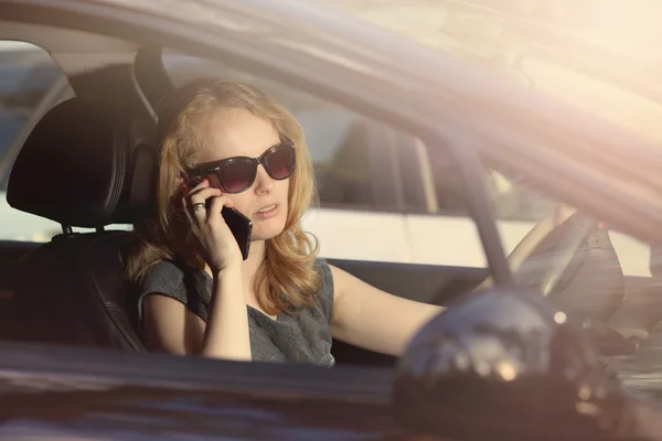 Młoda dziewczyna rozmawia przez telefon w samochodzie — Zdjęcie stockowe