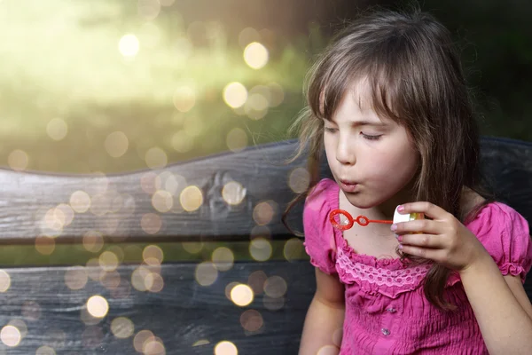 Bedårande liten flicka låter såpbubblor på en solig dag — Stockfoto