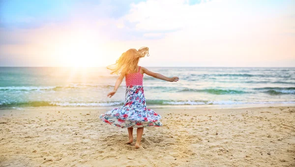 Chica despreocupada bailando en la playa en un vestido —  Fotos de Stock
