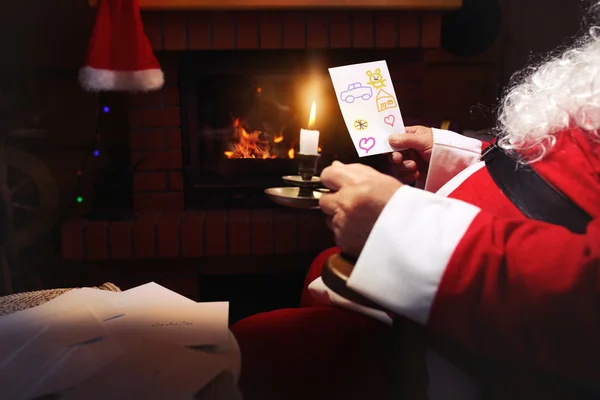 Santa Claus lee cartas escritas por niños alrededor de la chimenea —  Fotos de Stock