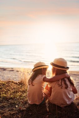 Cliff üzerinde oturan ve geleceğe bakan iki arkadaş