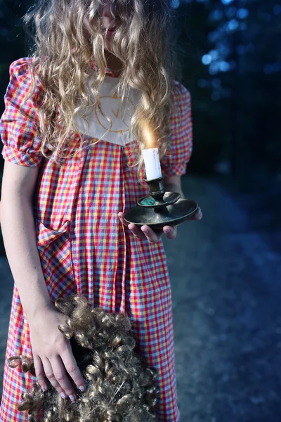 Misteriosa chica con una vela y una muñeca —  Fotos de Stock