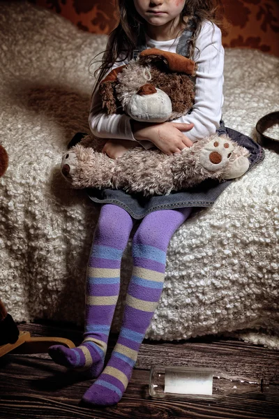 Scared little girl sitting on a bed in alcoholic families — Stock Photo, Image